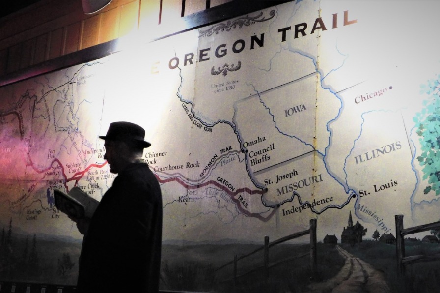 NW Ghost Tour in Oregon City Person leading ghost tour with Oregon Trail map in background