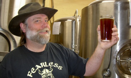 Owner of Estacadas Fearless Brewing, Ken, hoists a glass of his favorite Fearless Ale.