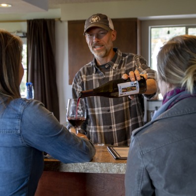 Winemaker pouring glasses for two tasters at King's Raven Winery
