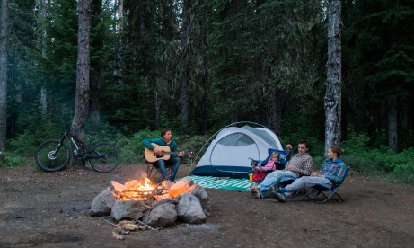 Campers enjoy guitar music as they sit around the campfire