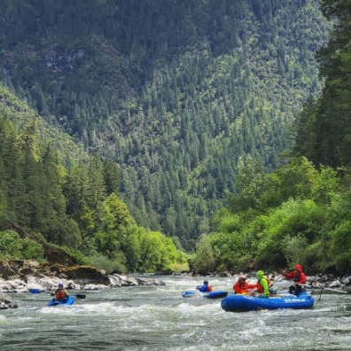 Rafters surrounded by green cliffs on the Clackamas River in Oregon