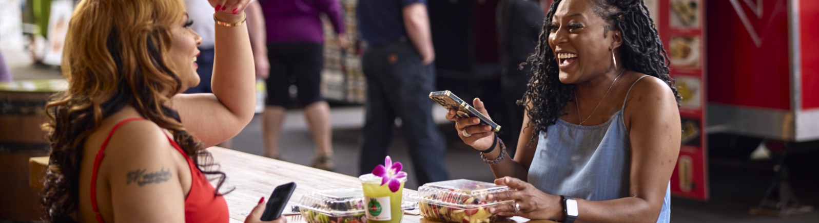 Two women eating at Happy Valley Station food carts.