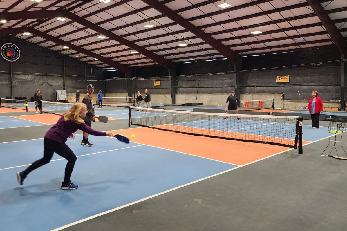 Four people play indoor pickleball at RECS
