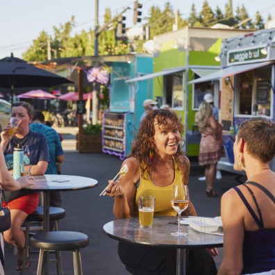 People eating at tables outside food carts in Oregon City