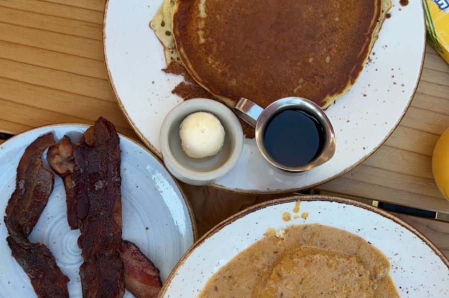 Brunch at Babica Hen in Lake Oswego Pancakes, bacon, and biscuits and gravy brunch on a wooden table