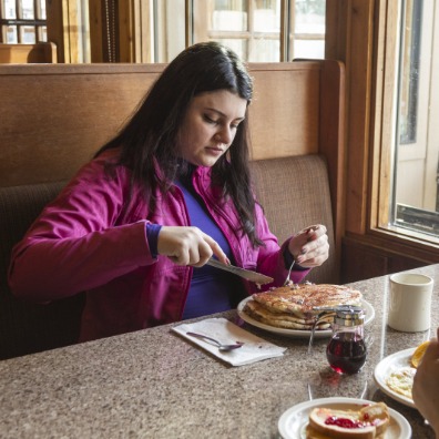 Two diners eat breakfast at a restaurant.