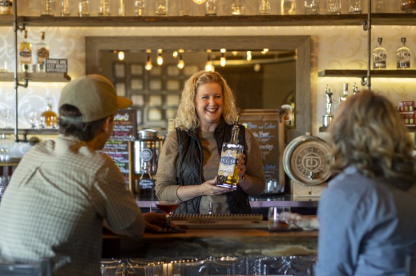 Bartender showing guests a bottle of gin