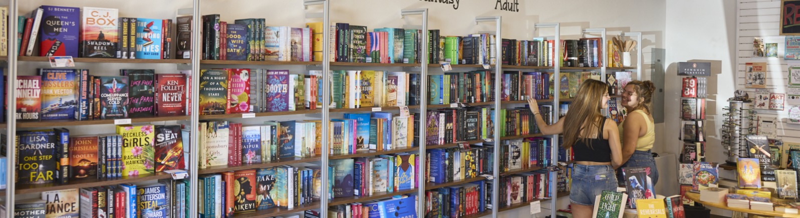 Wall of books reads "New Books" with genres listed below