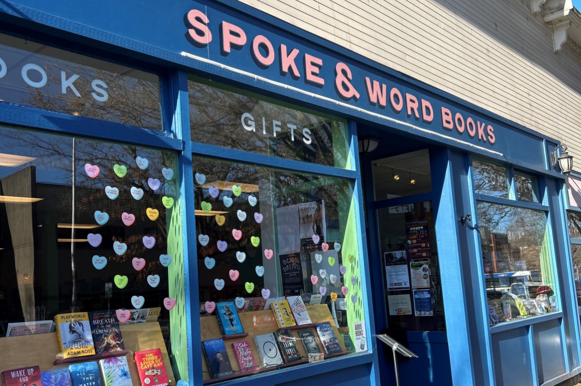 Blue storefront of bookshop with books on display in the front windows. 