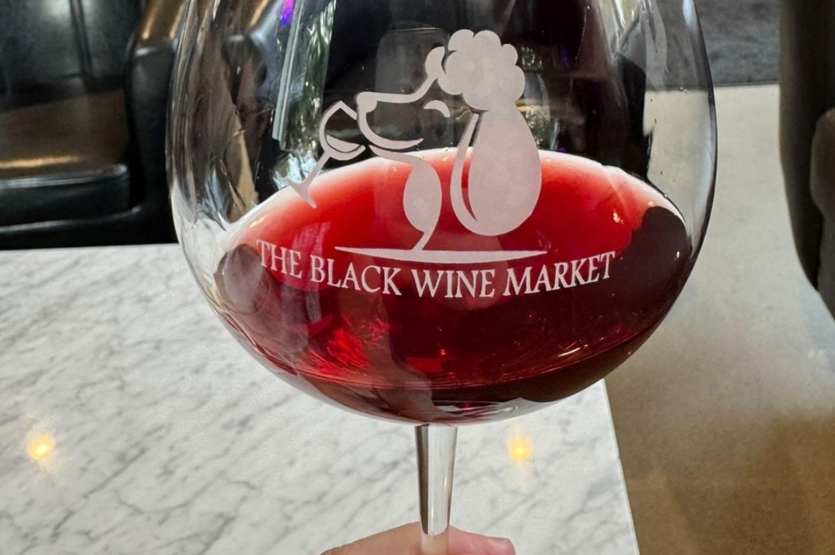 Red wine in a branded glass at The Black Wine Market.