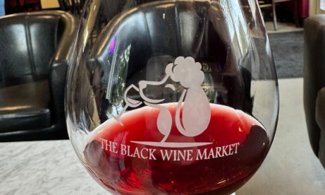 Red wine in a branded glass at The Black Wine Market.
