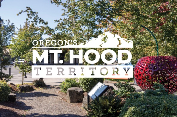 Logo for Oregon's Mt. Hood Territory overlayed on an image of a sculpture garden.