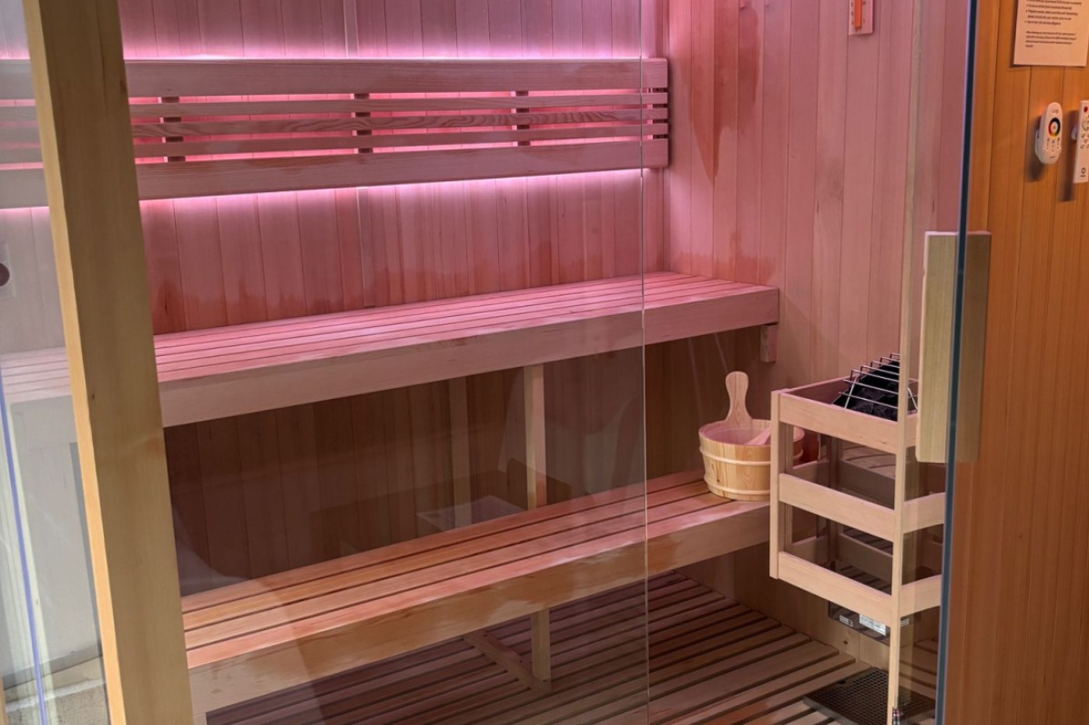 A wet-dry sauna features wood outside and glass walls.