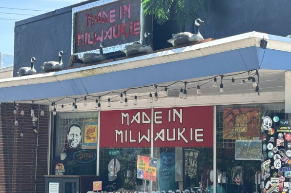 entrance to Made in Milwaukie has a tshirt rack out front and plastic geese on the roof.