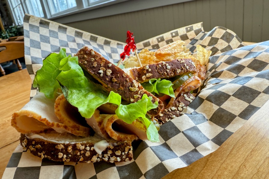 A sandwich on bread with green lettuce.