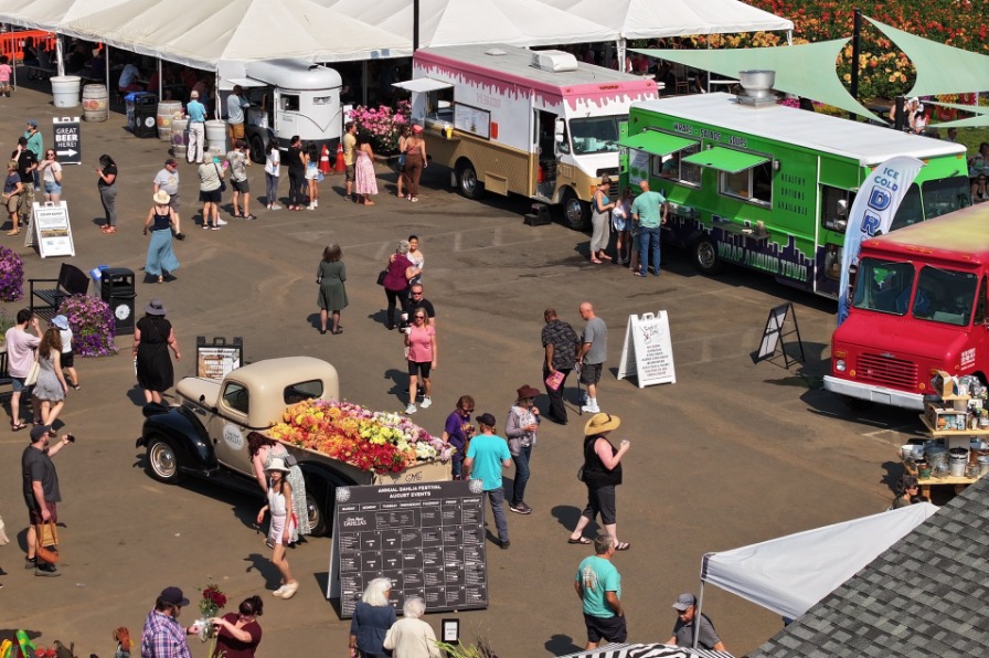 Colorful flowers surround food trucks
