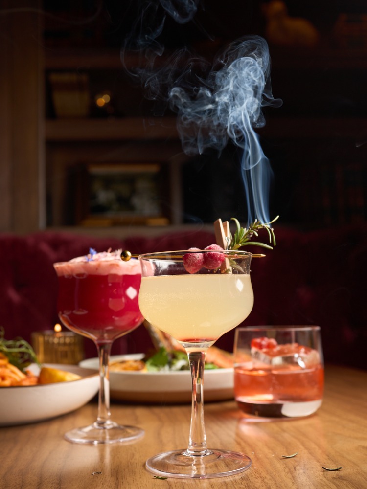 Cocktails on a table with plates of food