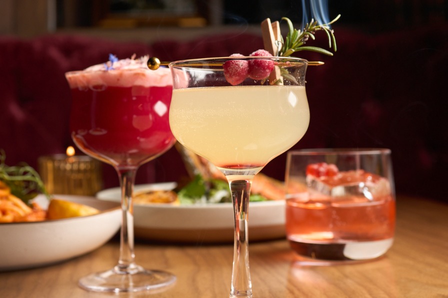 Cocktails on a table with plates of food