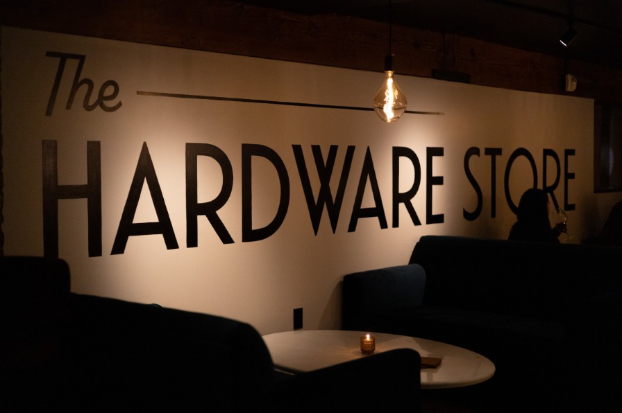 Sign reading The Hardware Store in a dark bar