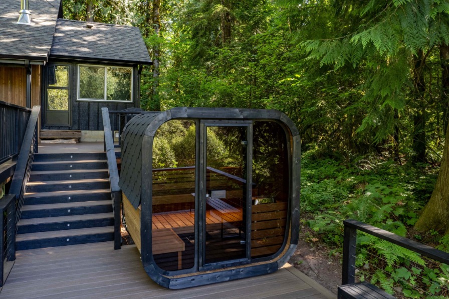 Cube glass front sauna sits on the deck at River Idyll. 