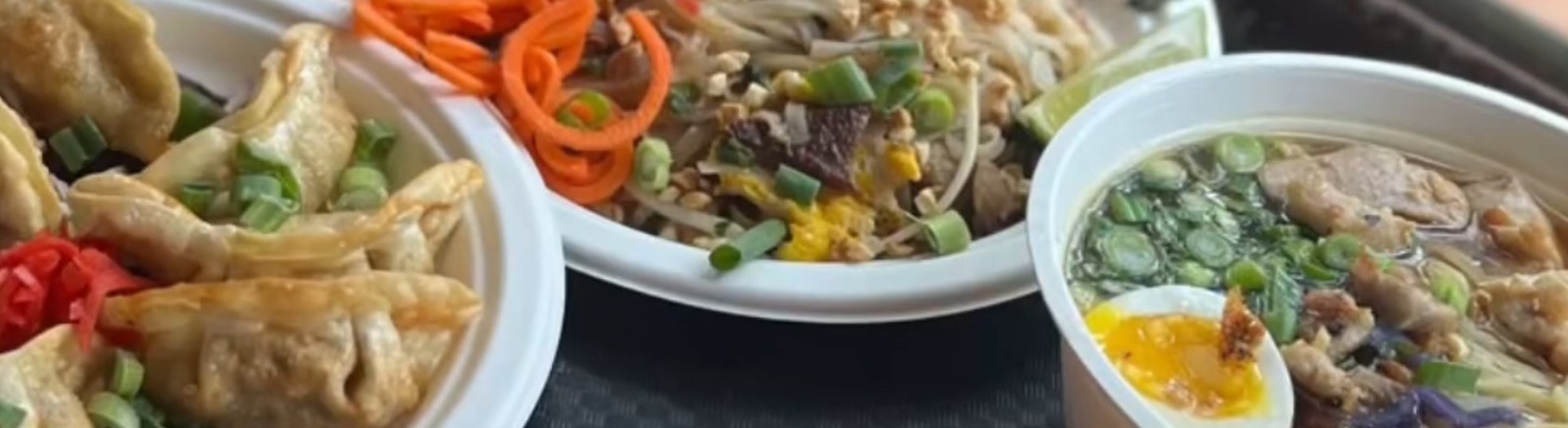 Two plates of fried rice, a bowl of ramen and a side of potstickers and thai iced tea