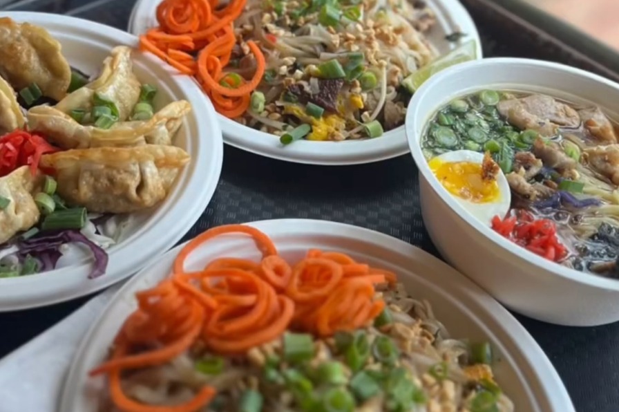 Two plates of fried rice, a bowl of ramen and a side of potstickers and thai iced tea