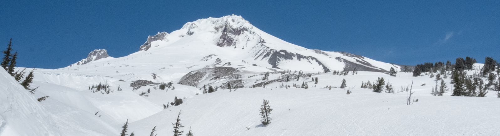 A mountain covered in white snow against a blue sky.