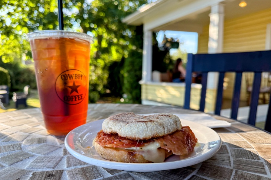 A cup of iced coffee and a breakfast sandwich