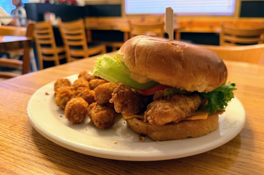 A chicken burger from the Historic Colton Cafe. A chicken burger on a bun with tater tots.
