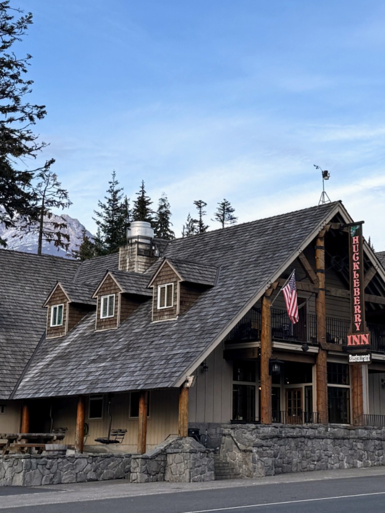A lodge stands again blue sky with Mt. Hood in the back