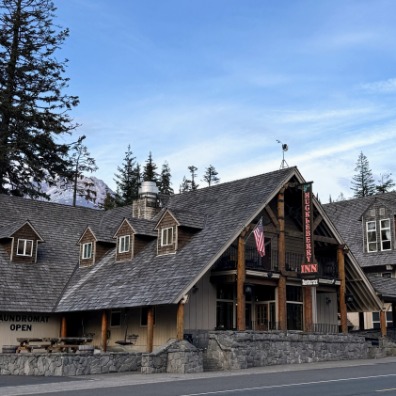 A lodge stands again blue sky with Mt. Hood in the back