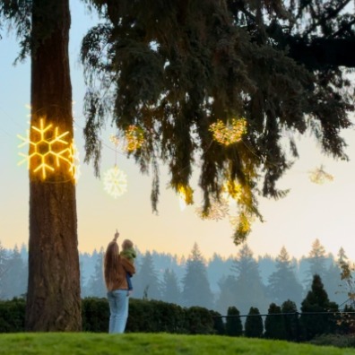Ornaments strung from trees with parent and child looking
