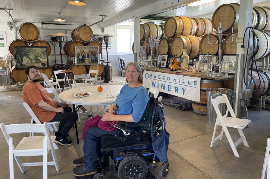 Two guests wine tasting among barrels