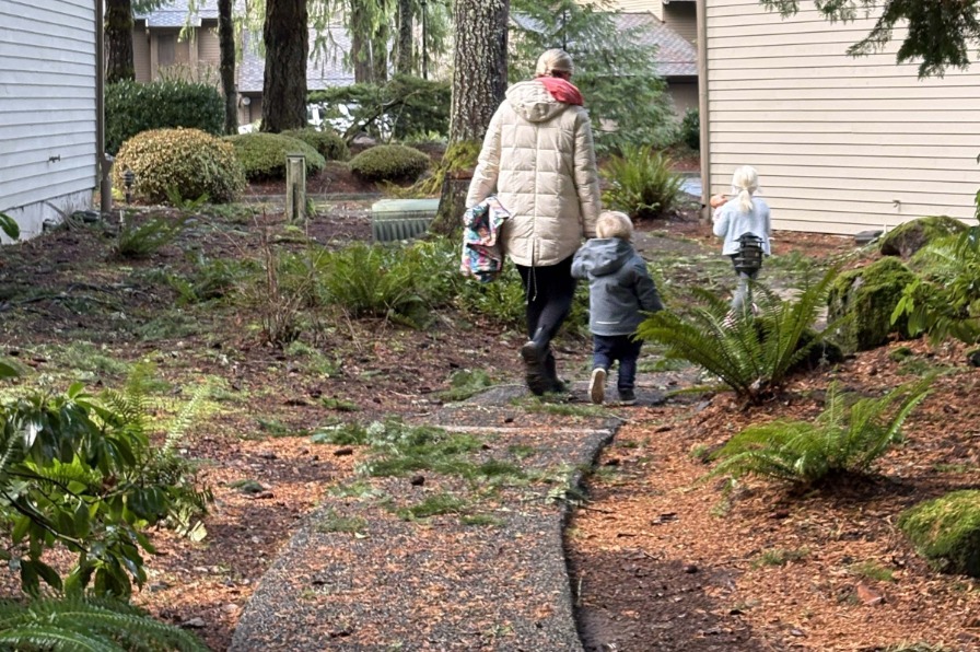 The Mt. Hood Oregon Resort An adult and two kids walk on a path under green trees