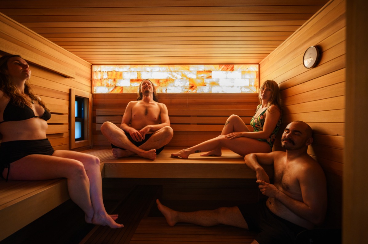 Four people relax in a sauna