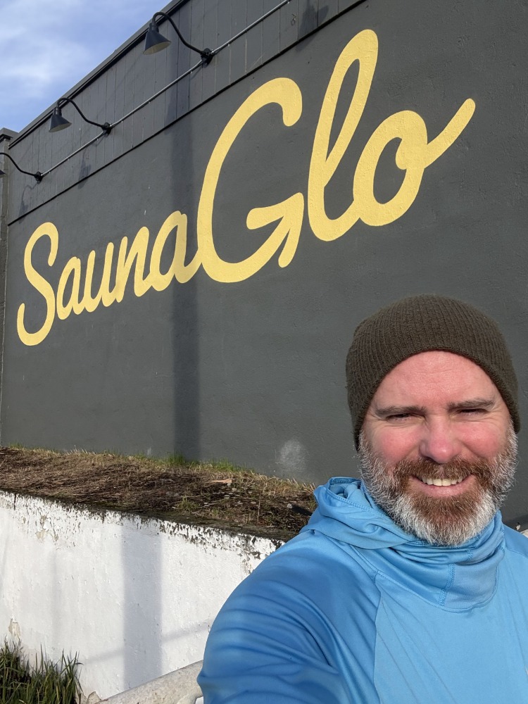 A person in front of a sign for SaunaGlo
