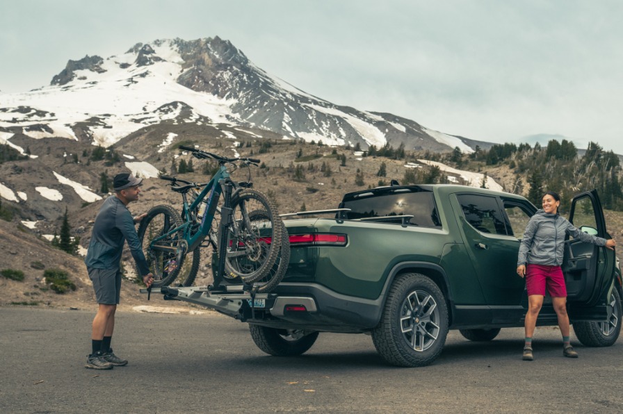 A green truck in front of a snow covered mountain