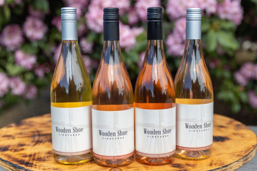 Four glass bottles of wine line a table