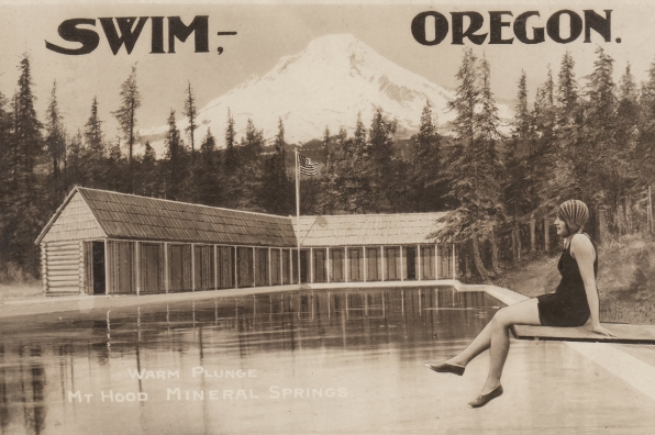 Vintage sepia toned image shows a person in a bathingsuit & cap sitting on the diving board at the Mt. Hood Mineral Springs in the lost township of Swim, Oregon