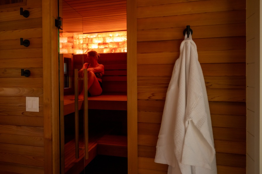 A person relaxes in a wooden spa.