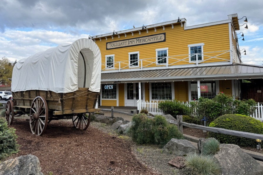 A yellow building with a white covered wagon 