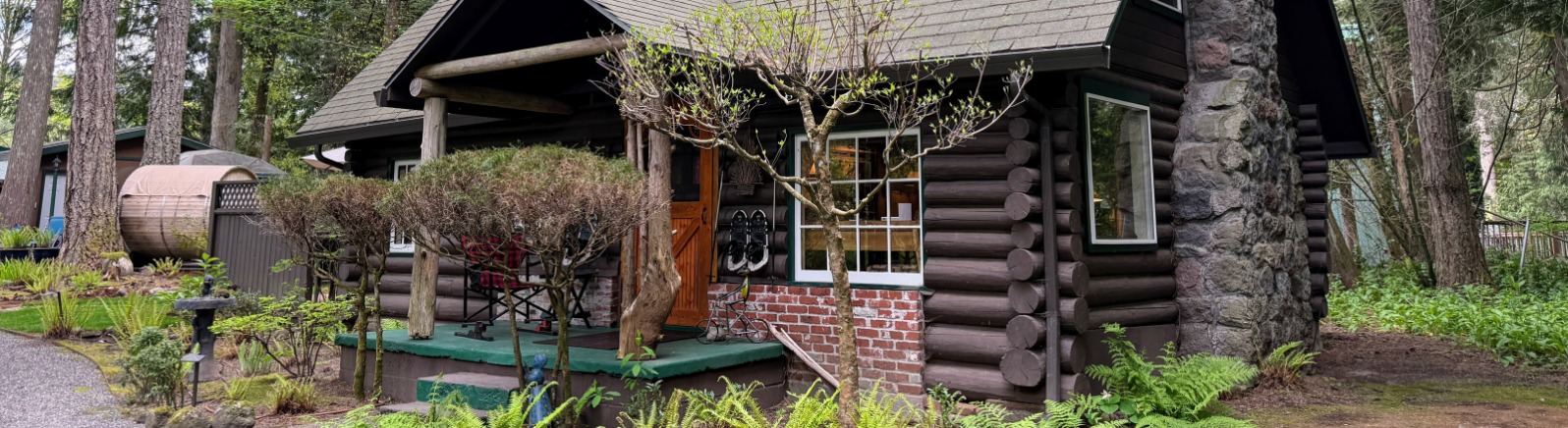 A wood cabin with green trees