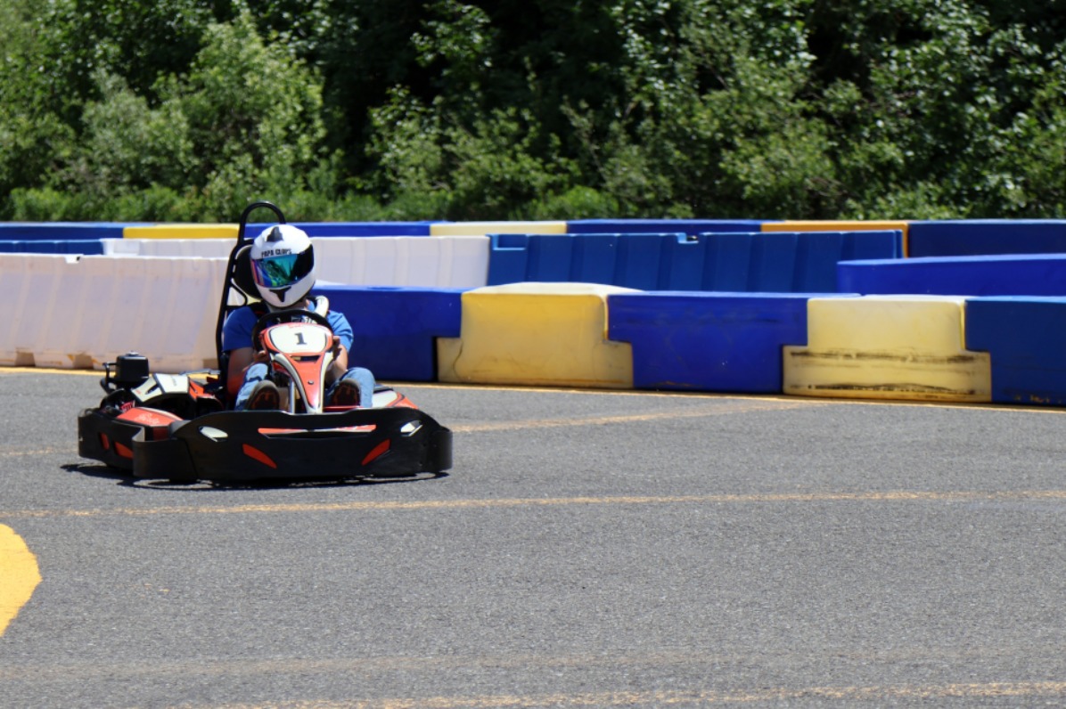 A go kart on a grey track.