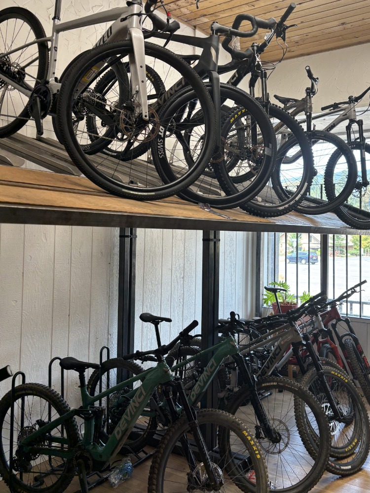 A row of mountain bikes on a wood shelf in a store
