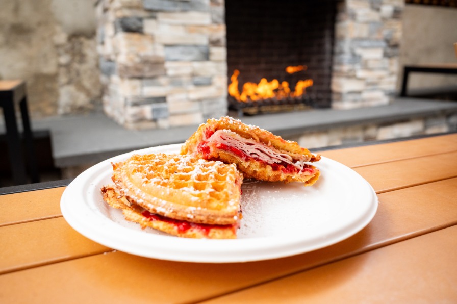 Waffles on a white plate with a firepit behind