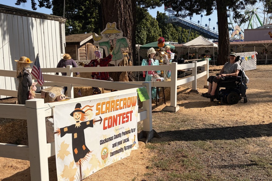 The Clackamas County Fair Wooden scarecrows in a white fence
