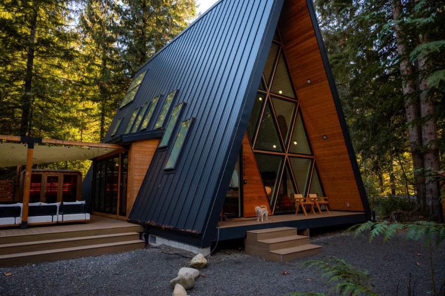 PortlandiA Aframe Cabin An a frame building with glass windows sits in a green tree grove