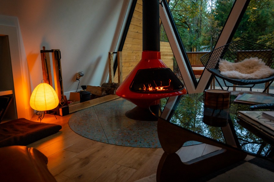 PortlandiA Aframe Cabin A round light, floating fireplace inside a cabin.