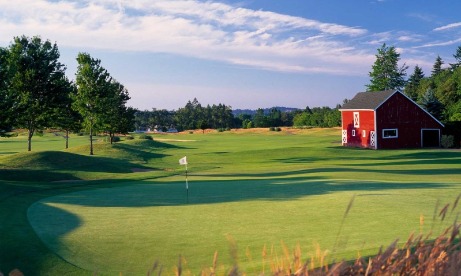 Manicured 8th hold green and small red barn near cart path with view of long fairway at Langdon Farms Golf Club in Aurora.