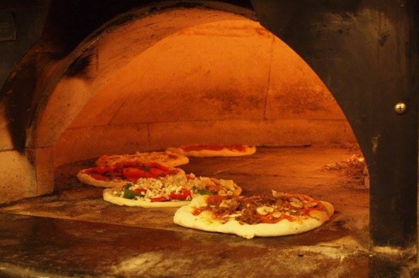 5 pizzas all cooking at one time in wood oven at Oregon Citys Mi Famiglia Wood Oven Pizzeria in Oregons Mt Hood Territory